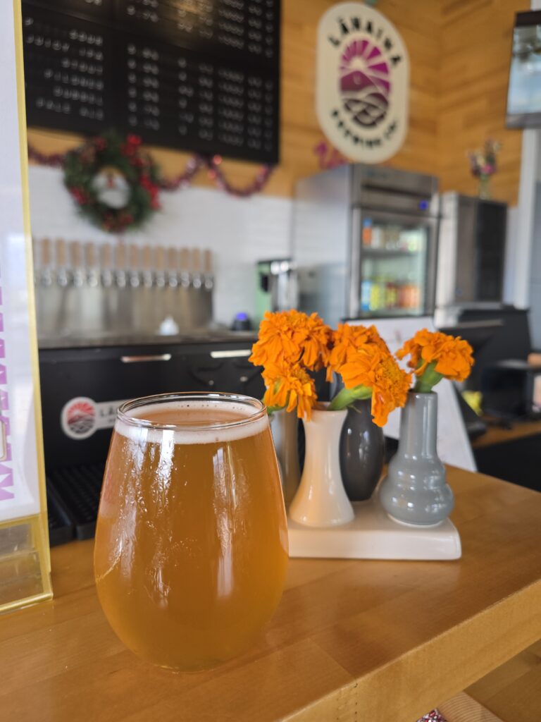 glass of beer with flowers in front of tap wall